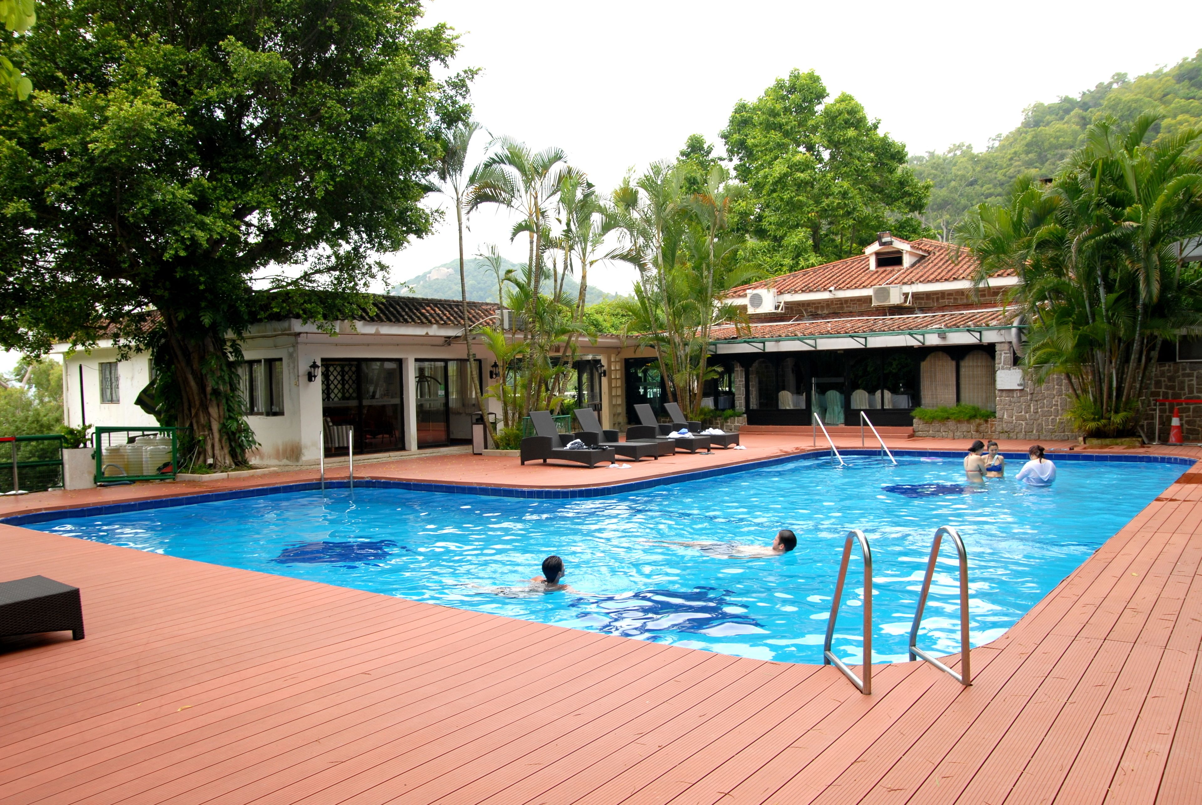 Una piscina al aire libre de temporada, sombrillas