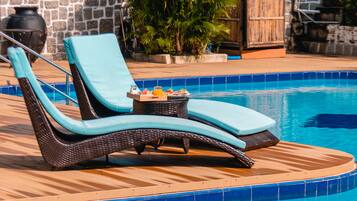 Una piscina al aire libre de temporada, sillones reclinables de piscina