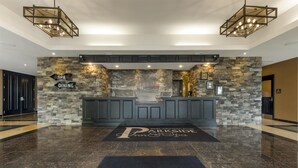 Zona de recepción con pared de piedra, un cartel que indica SPA y COMEDOR, y el logotipo de PARKSIDE Inn & Spa.