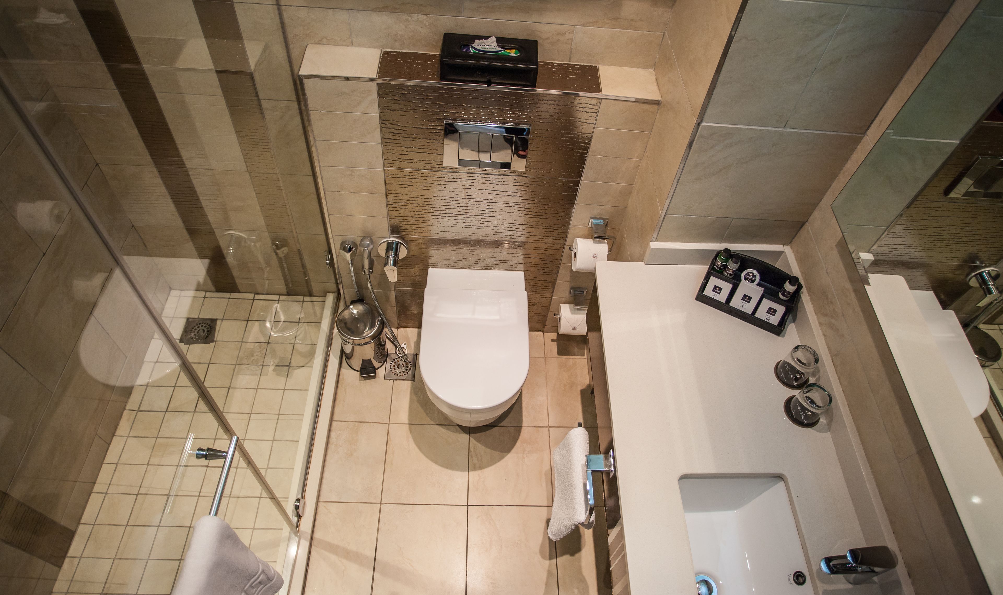 Een moderne badkamer met toilet, hygiëneschuimer en douche.