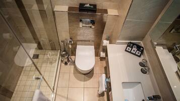 Een moderne badkamer met toilet, hygiëneschuimer en douche.