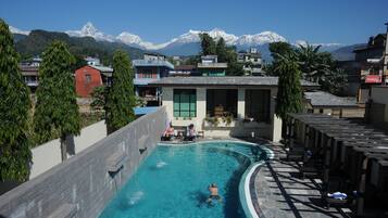 Relax by the pool surrounded by lounge chairs and stunning mountain views.