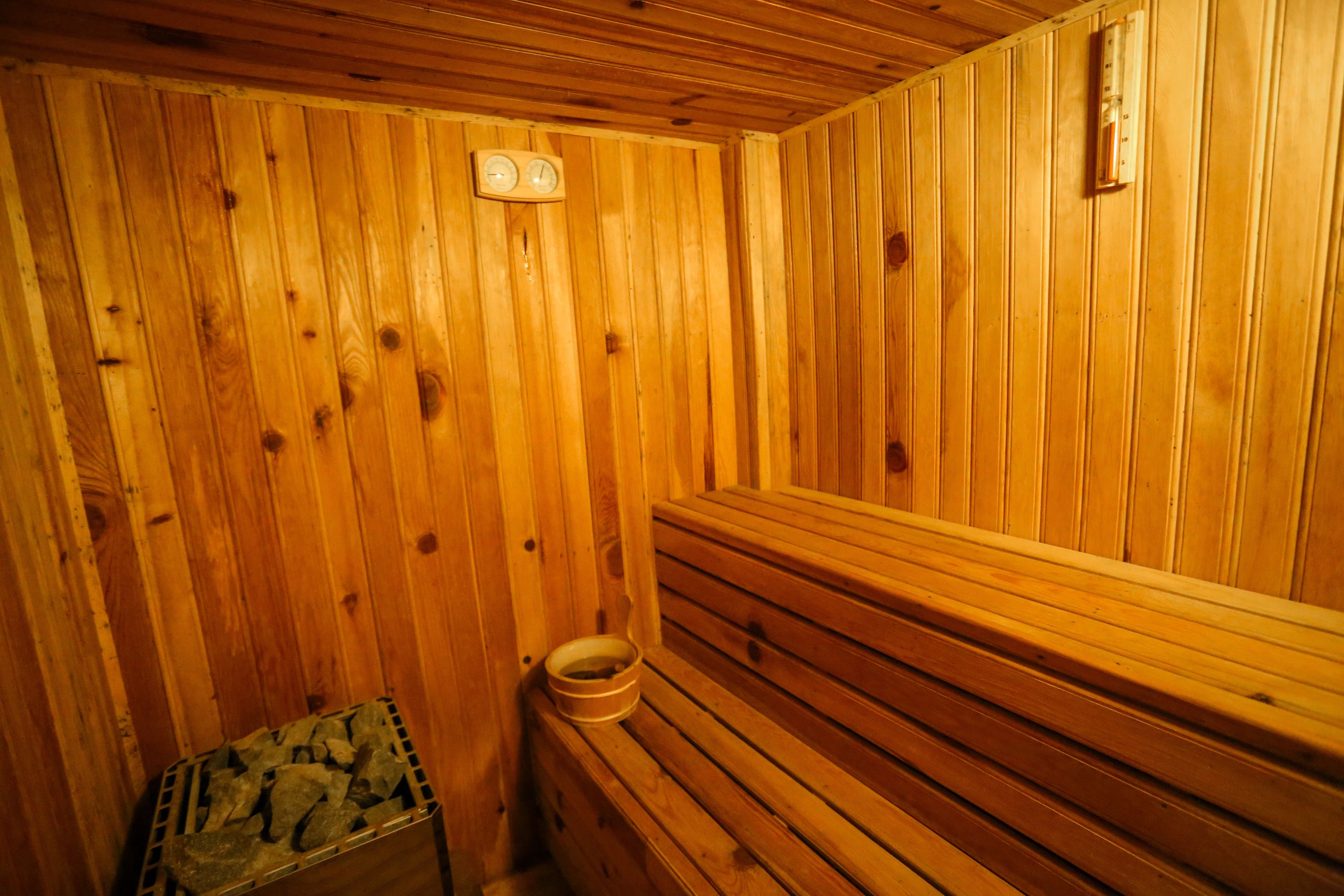 Una sauna de madera con bancos y un pequeño banco de madera.