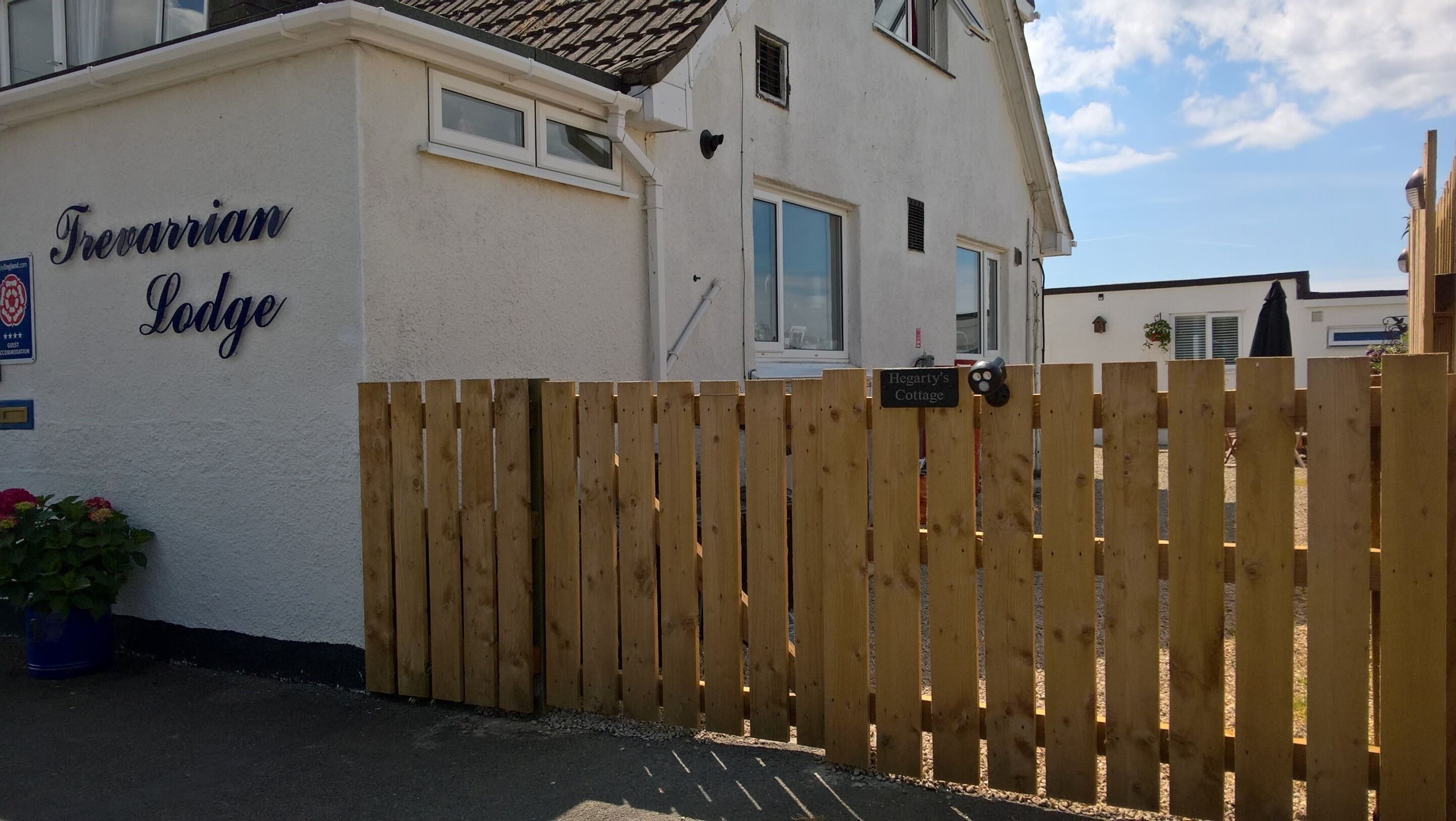 A wooden fence in front of a building labeled "Trevarrian Lodge".