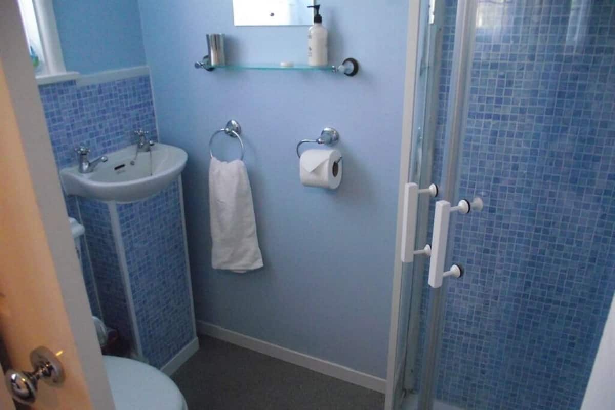 A bathroom with a sink, toilet, and glass shower enclosure.