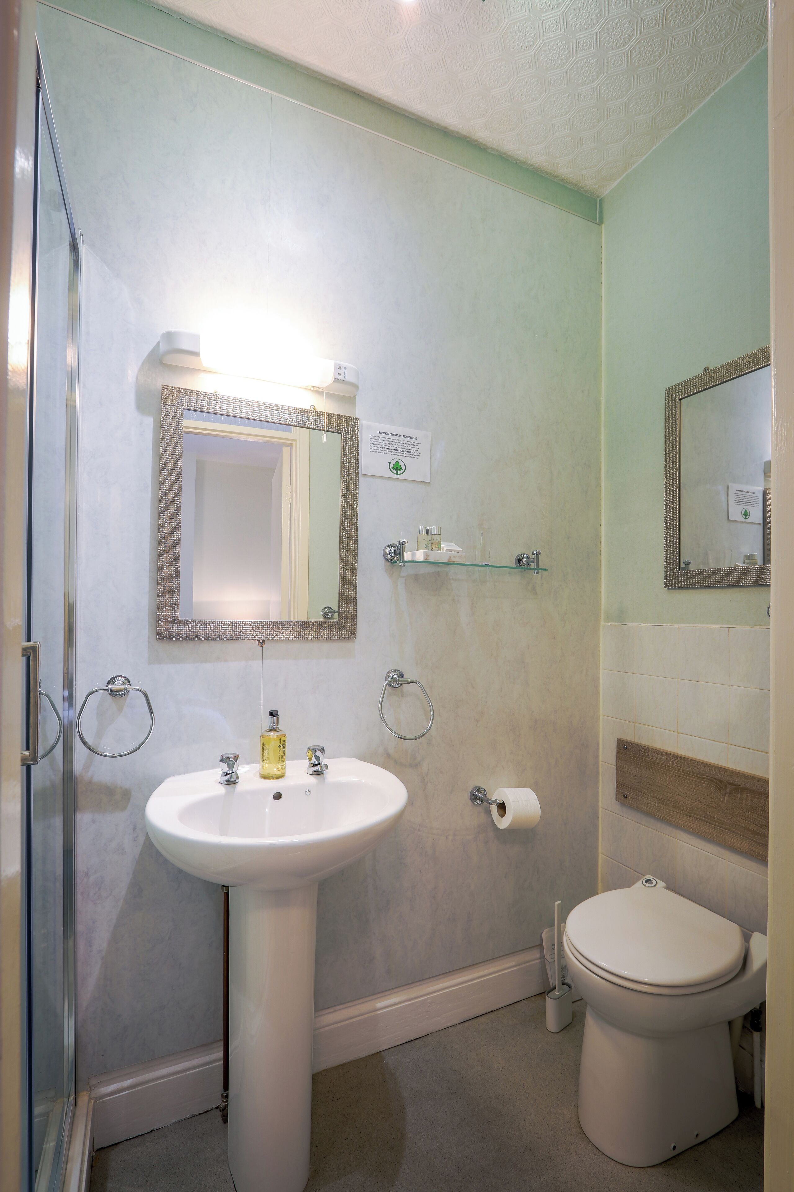 A bathroom with a white sink, a toilet, and a shower area.