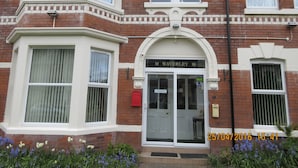 A two-story brick building with a white-framed entrance and a sign reading "10 Waverley 10". - Waverley Bed & Breakfast (Minehead)