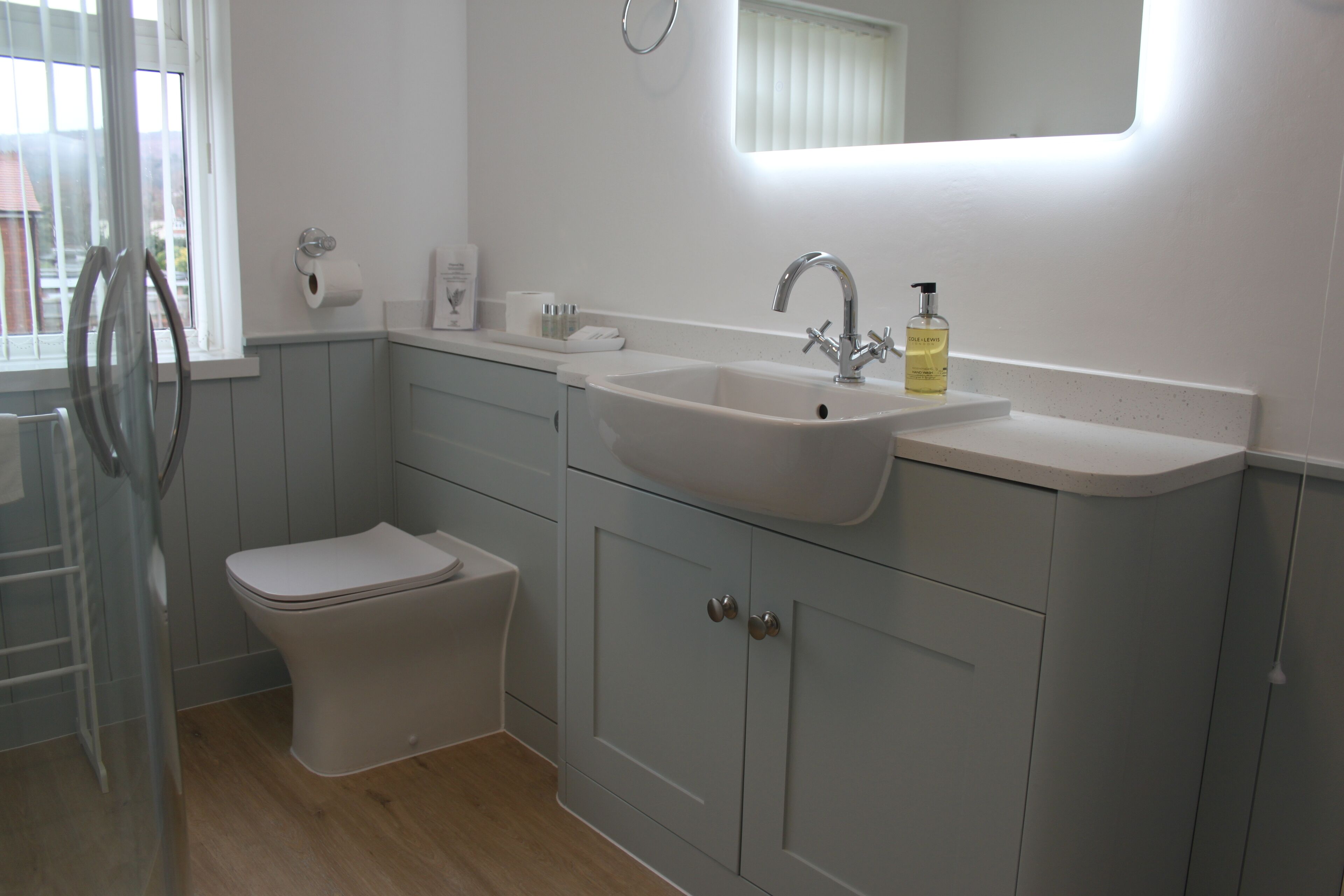 A bathroom with a white sink, a toilet, and a mirror above the sink.