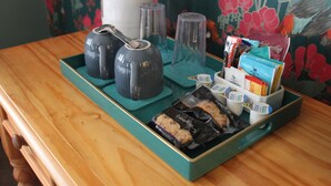 A tray with tea kettles, cups, and packaged cookies on a wooden table. - Waverley Bed & Breakfast (Minehead)