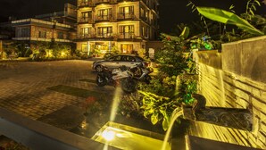 A multi-story hotel with a well-lit entrance and a parked motorcycle. - Hotel Tara (Pokhara)