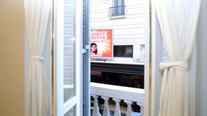 A view through a doorway with a poster advertising 'Christ the Superstar' and a balcony with a railing. - Relais Sistina (Rome)