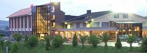 A modern hotel with a glass facade, a flat roof, and a well-maintained garden. - Hotel Restaurant Royal (Llanera)