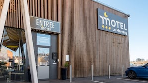 The exterior of a motel named 'Le Mercenay' with a wooden facade and a sign indicating the entrance. - Le Merceny Motel (Bastogne)