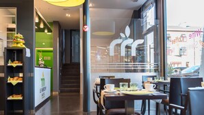 A modern hotel lobby with a reception desk, a staircase, and a dining area with tables and chairs. - Le Merceny Motel (Bastogne)