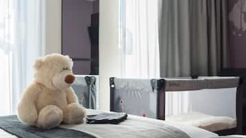 A bed with a teddy bear, a remote control, and a grey headboard.