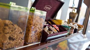 A display case with various food items, including granola and chocolates, in a store.