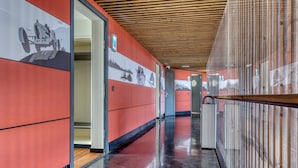 A corridor with red walls, a wooden ceiling, and a polished floor. - Le Merceny Motel (Bastogne)