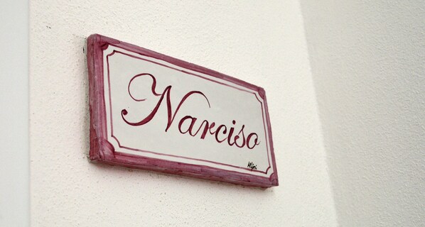 Un letrero con el nombre 'Narciso' en una pared.