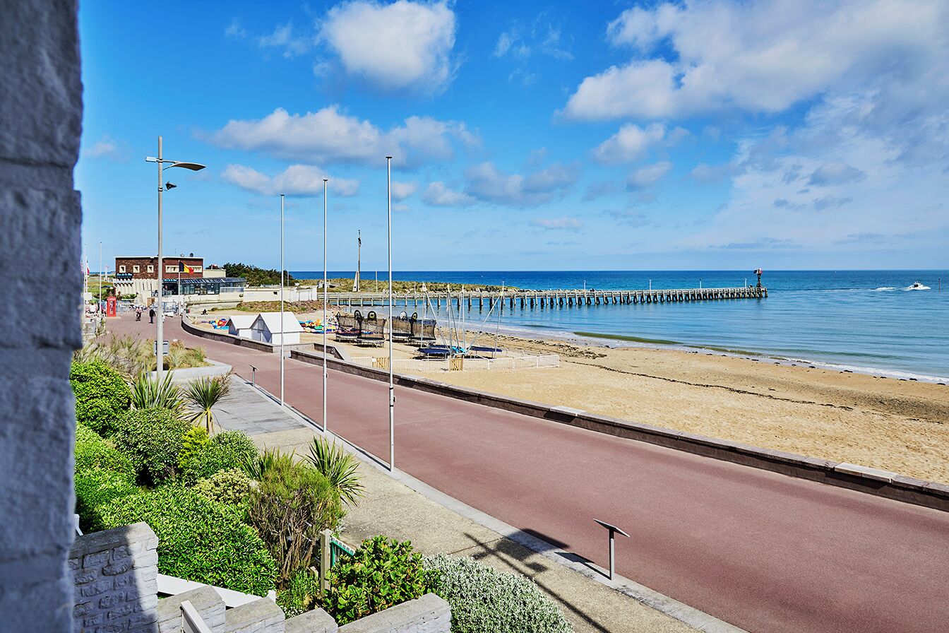 Eine Küstenstraße mit Strand und Steg.