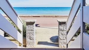 A view from a balcony overlooking a beach with a clear sky.