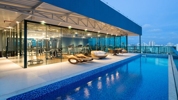 A modern building with a glass facade, a rooftop pool, and a view of the city skyline. - Sotero Hotel (Salvador)