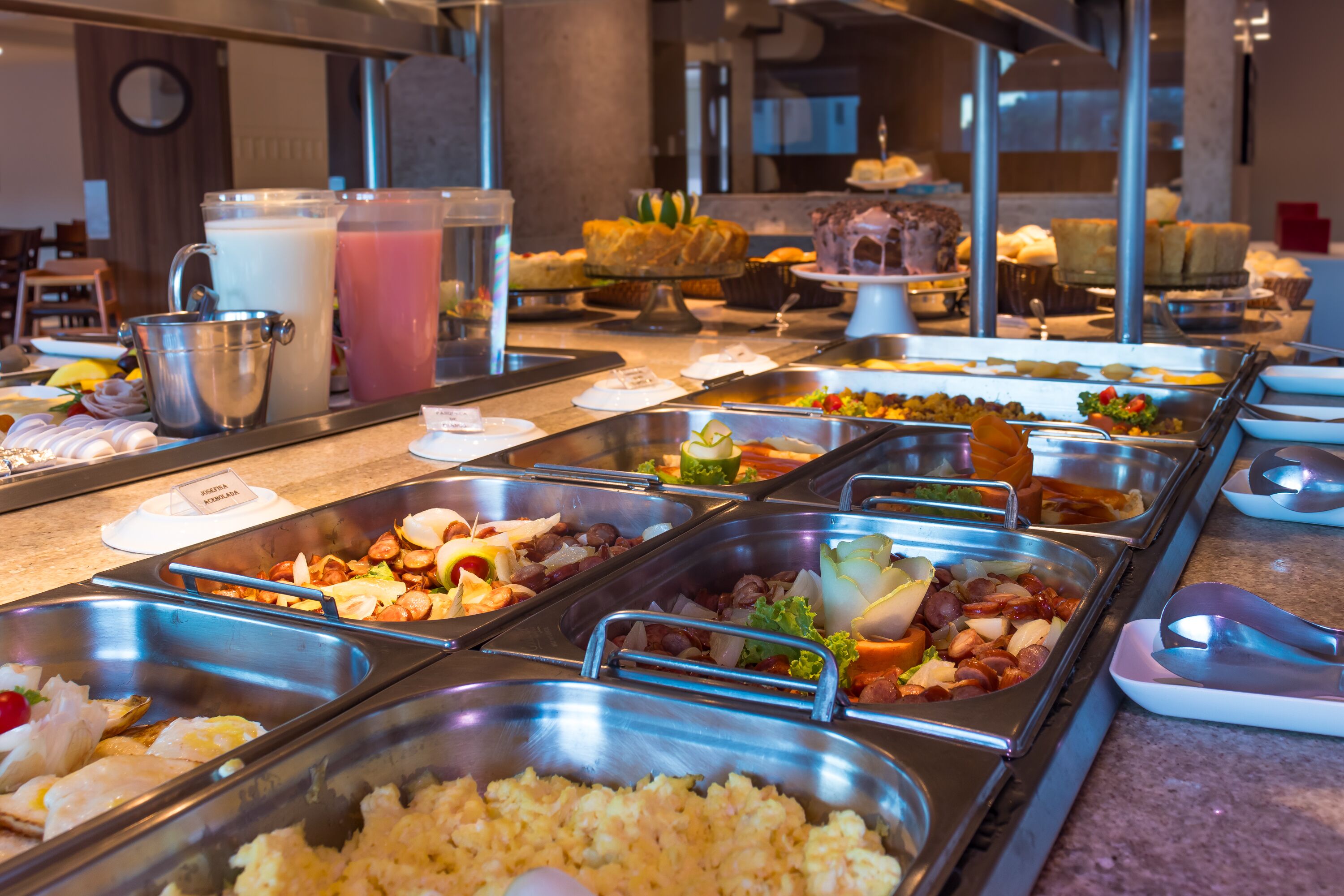 A buffet with various food options including fruits, vegetables, and meats.