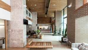 A spacious lobby with a wooden ceiling, a seating area with a bench, and a reception desk. - Sotero Hotel (Salvador)