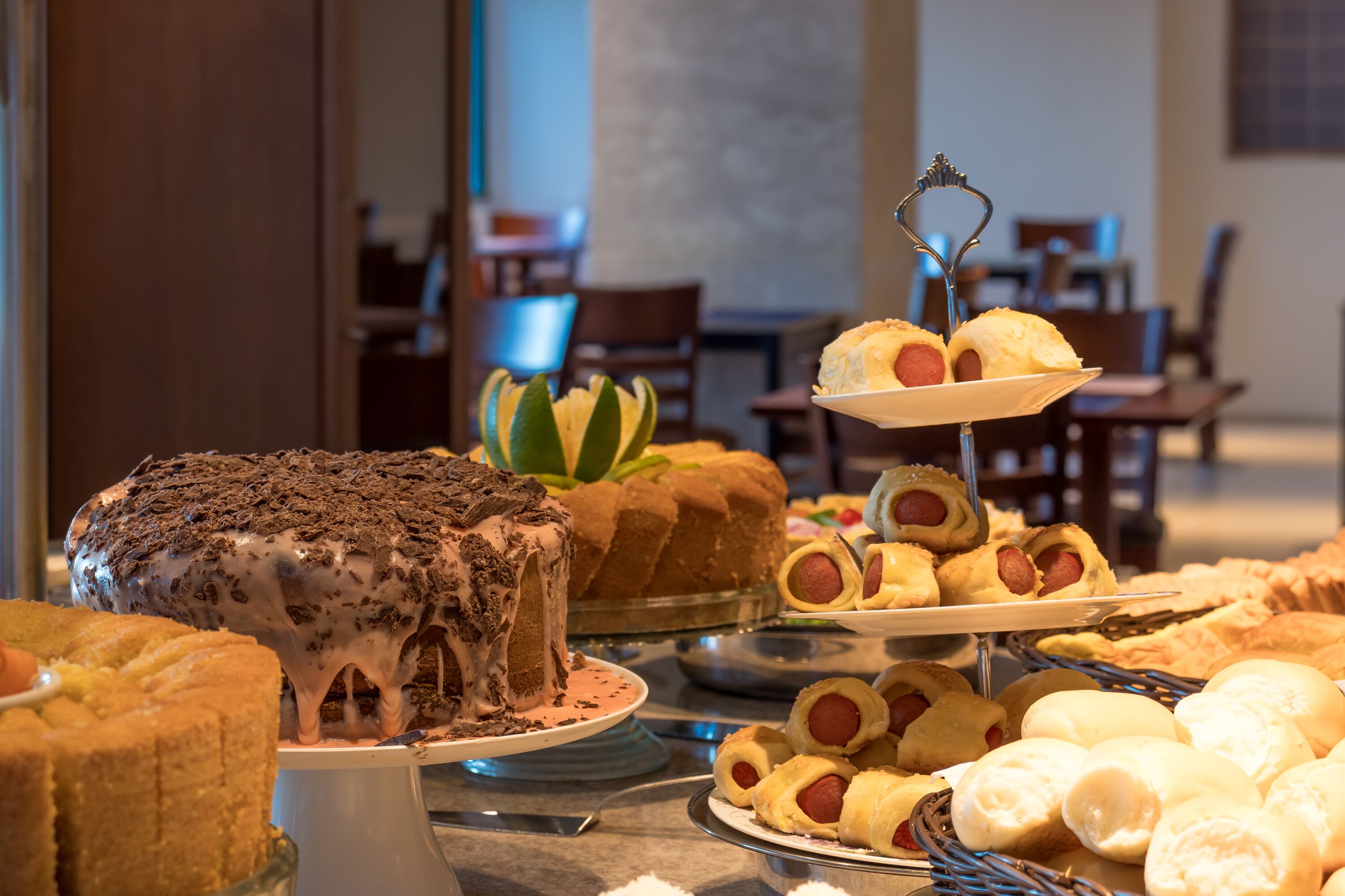 A buffet with various desserts and hot dogs.