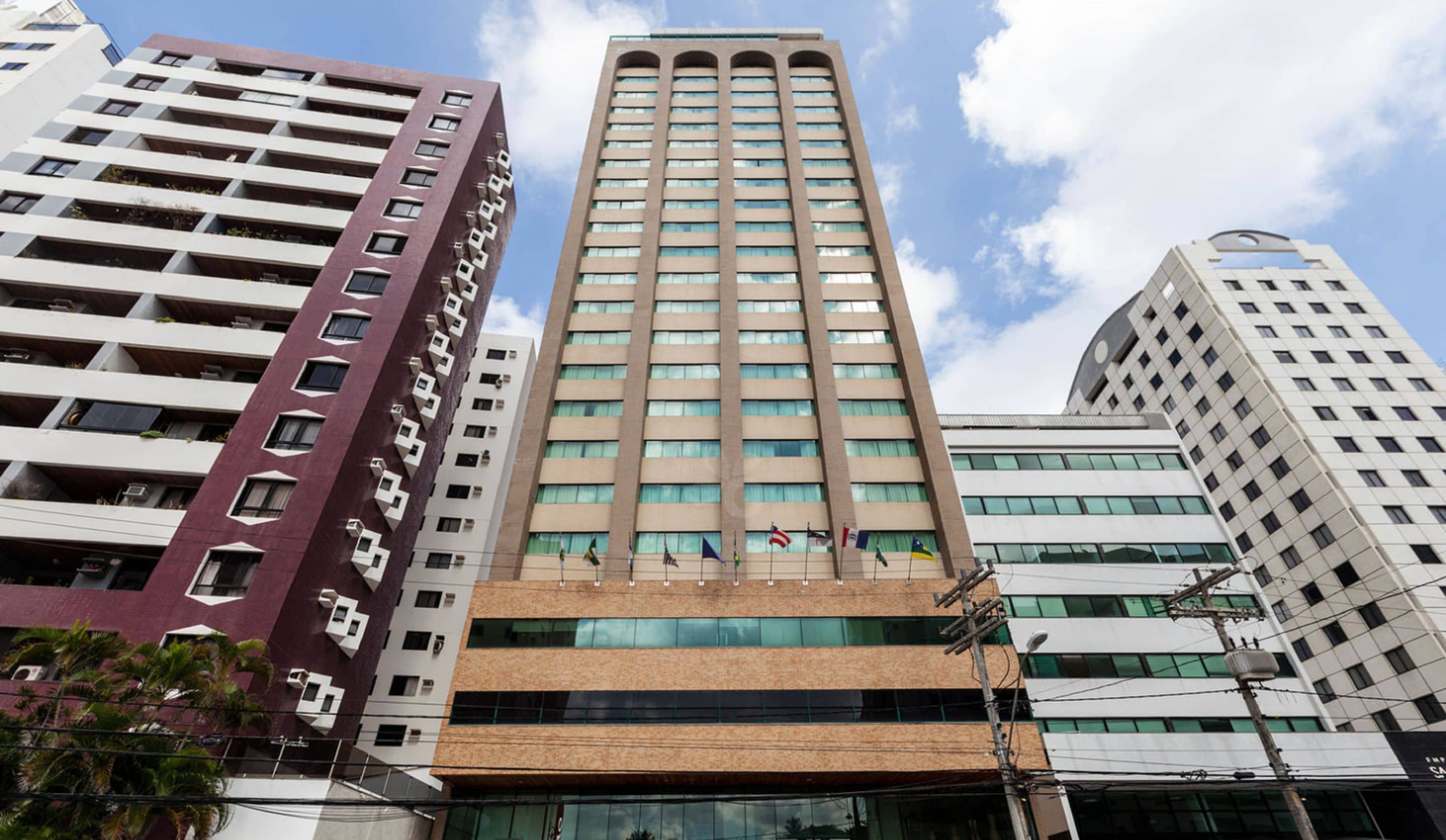 A tall, modern building with multiple floors, featuring a mix of glass and concrete facades.
