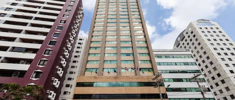A tall, modern building with multiple floors, featuring a mix of glass and concrete facades.