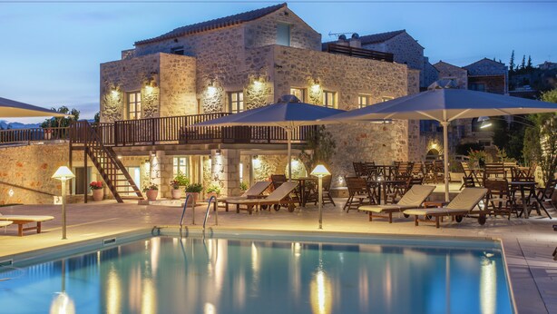 A stone building with a pool, lounge chairs, and umbrellas. - Thirides Beach Resort (East Mani)