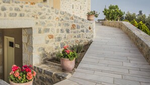 A stone building with a beige facade and a paved walkway. - Thirides Beach Resort (East Mani)