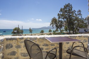 En la playa, sillas reclinables de playa, sombrillas, windsurf