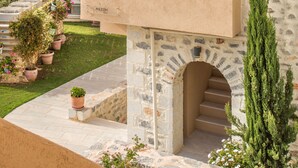 A stone building with a balcony, a staircase, and potted plants. - Thirides Beach Resort (East Mani)