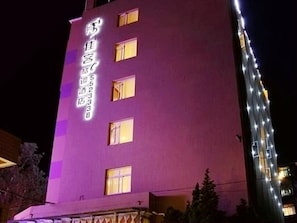 A building with illuminated signage, multiple windows, and a visible entrance area.