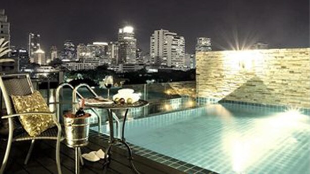 Una piscina al aire libre con un horizonte urbano de fondo.