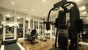 Un gimnasio con cintas de correr, elípticas y máquinas de pesas.