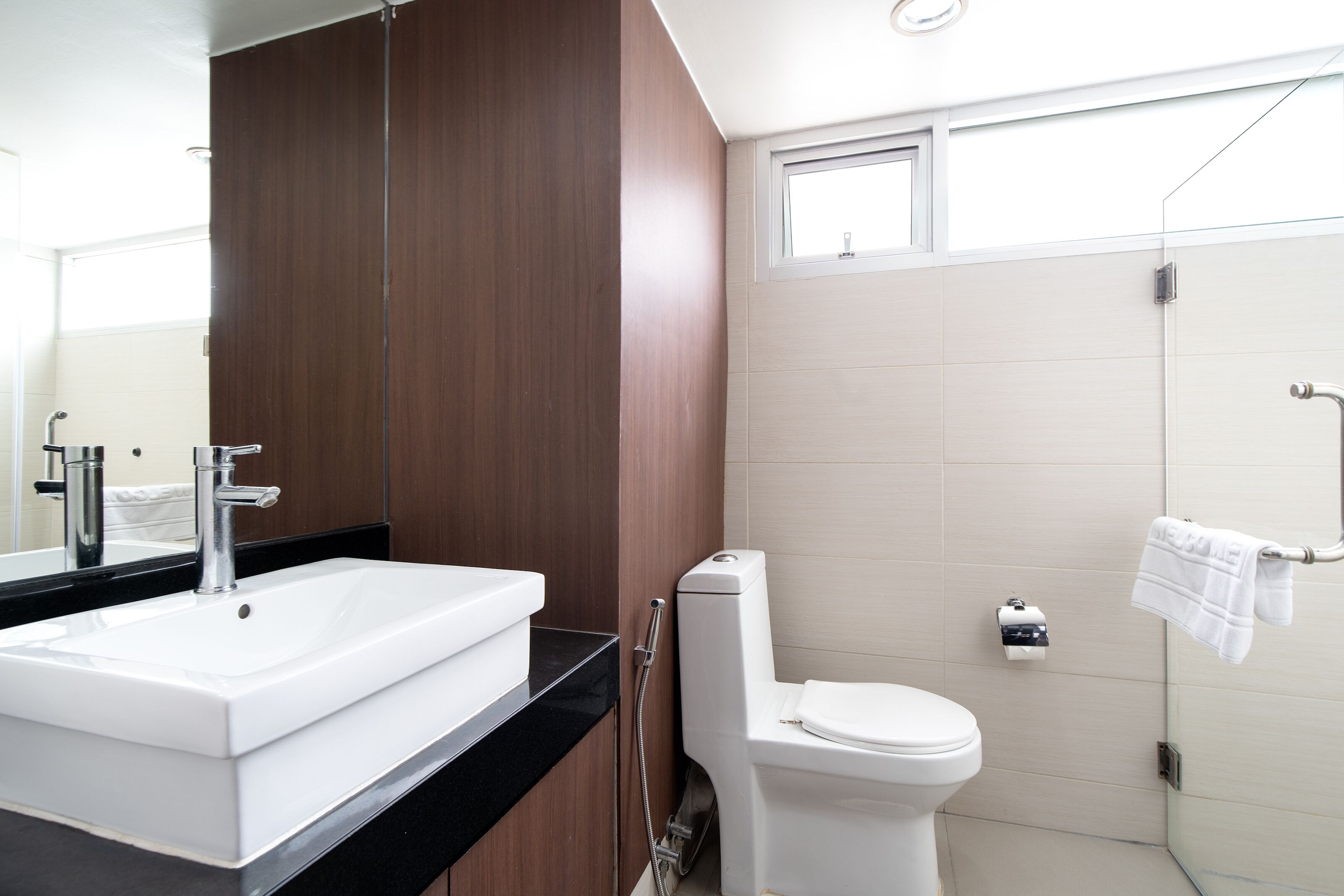 Un baño moderno con lavamanos, inodoro y ducha blancos.
