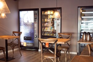 Ristorante con arredi in legno, due distributori automatici e un angolo caffè.