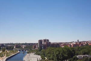 Eine Stadtansicht mit einem Fluss, einer Brücke und einer Mischung aus Wohn- und Geschäftsgebäuden.