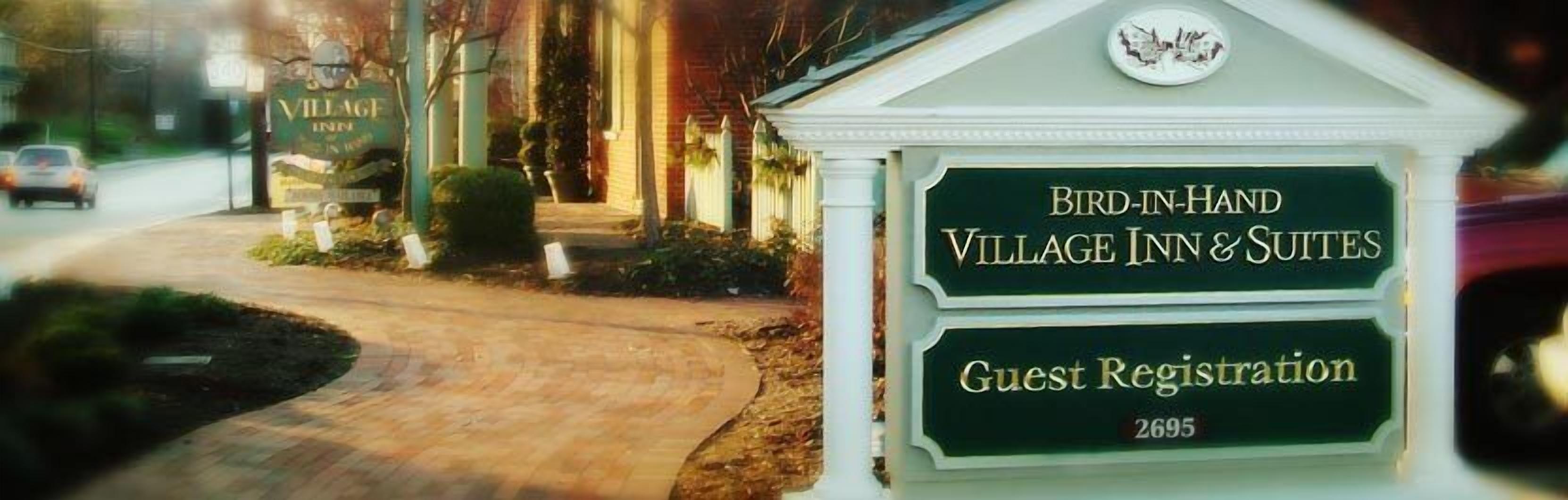 A sign for the Village Inn & Suites with a guest registration area.