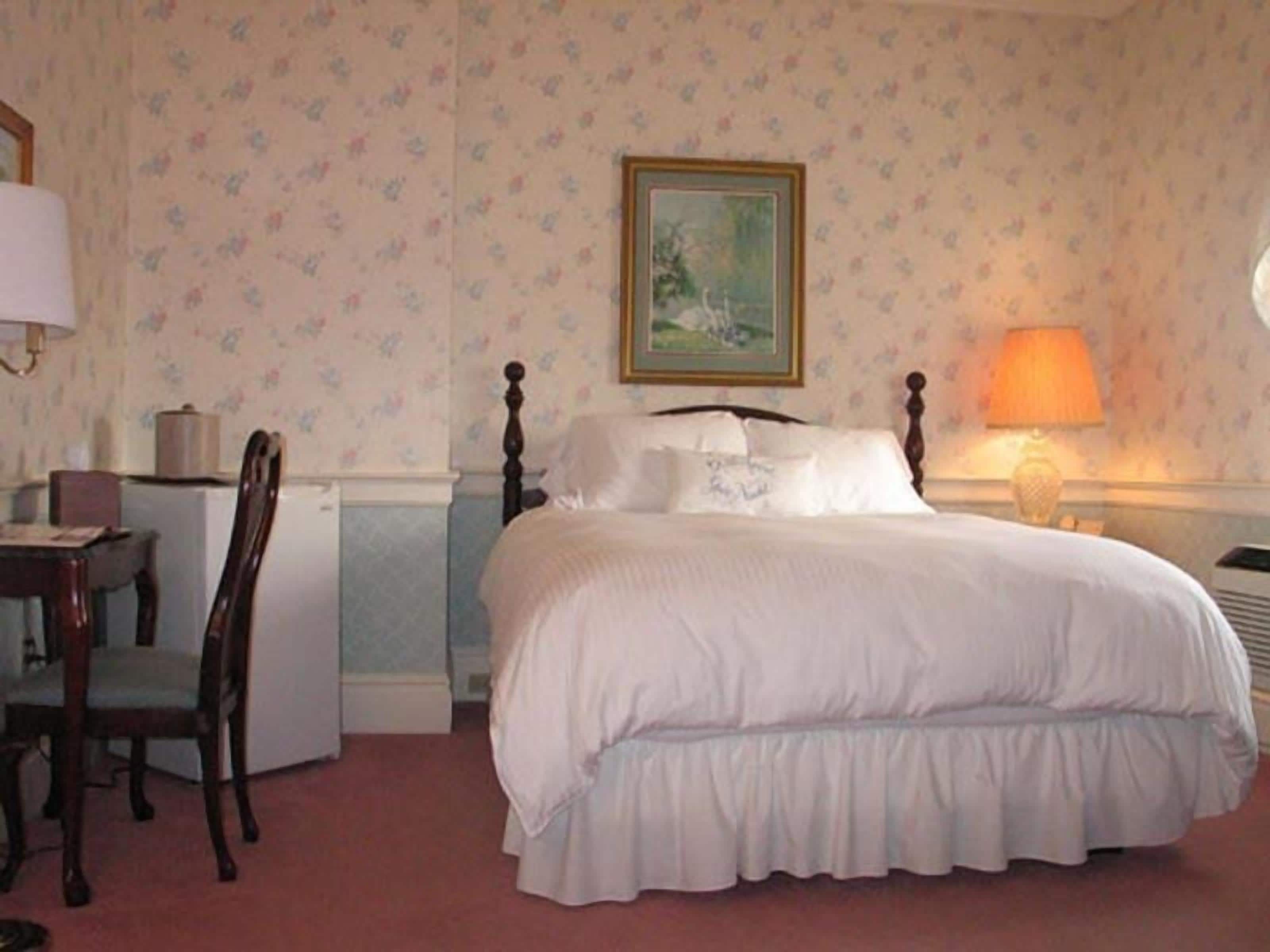 Une chambre bien rangée, avec un lit, un bureau et une chaise.