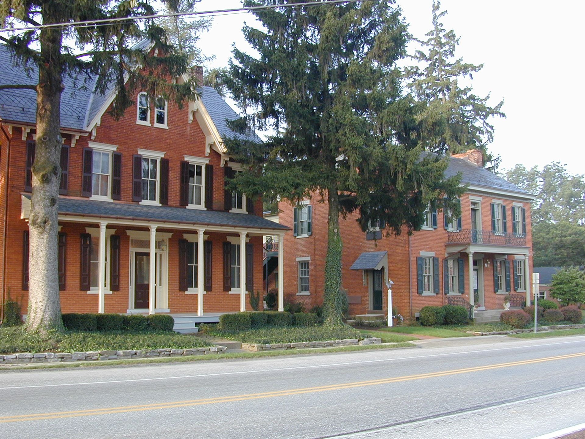 A two-story brick house with a porch and large windows.