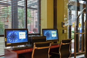 Two computer monitors on a desk with a keyboard, a chair, and a door with a sign indicating the use of a key card for entry. - Holiday Inn Express New York - Manhattan West Side by IHG (New York)