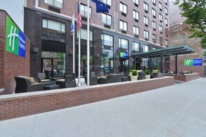 A Holiday Inn Express building with outdoor seating and a covered patio area. - Holiday Inn Express New York - Manhattan West Side by IHG (New York)