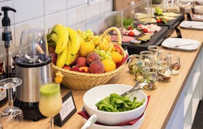 A buffet setup with a variety of fruits, a salad bowl, and several small glass containers, likely containing condiments or dips. - Coffee Fellows Hotel Siegburg West (Siegburg)