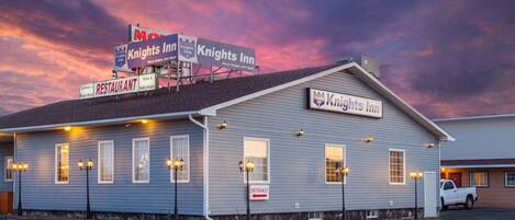 A Knights Inn building with a sign indicating it is a restaurant and a parking area.