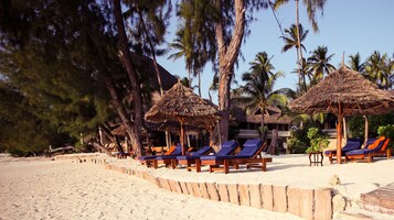 On the beach, white sand, sun loungers, beach umbrellas