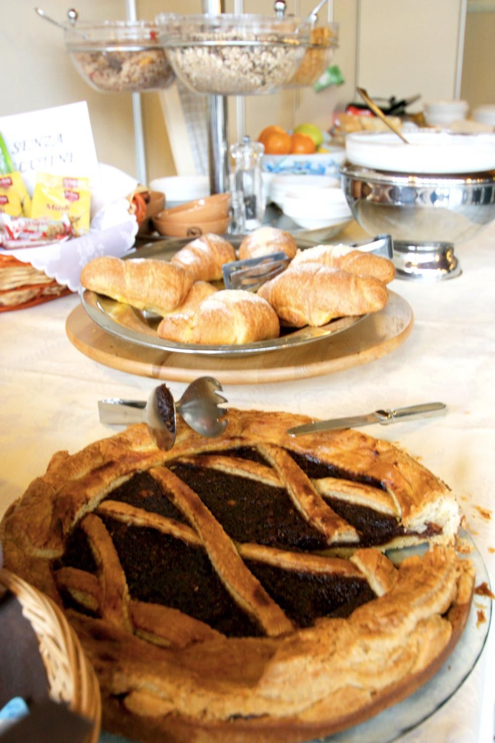 A buffet table with a variety of food items including a pie and pastries.