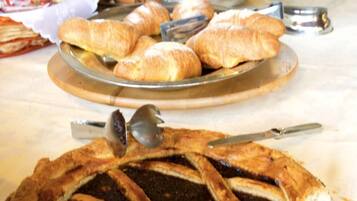 A buffet table with a variety of food items including a pie and pastries.